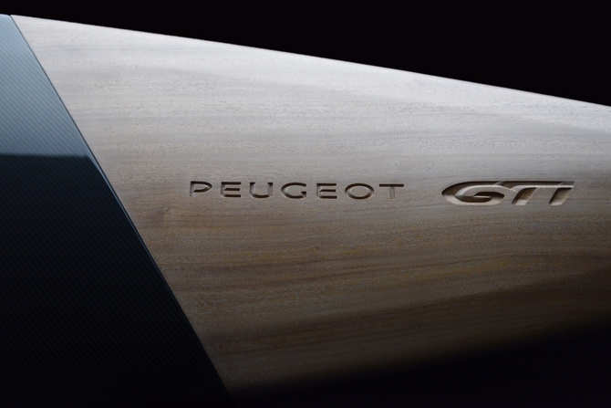 A frente é feita de madeira com o nome Peugeot GTI gravado sobre ela A frente é feita de madeira com o nome Peugeot GTI gravado sobre ela